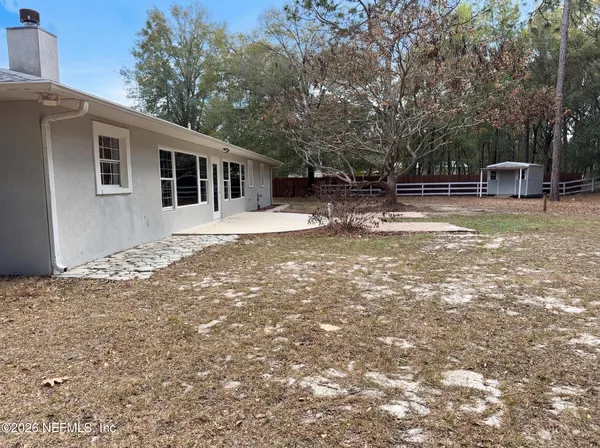 a view of a house with backyard and trees