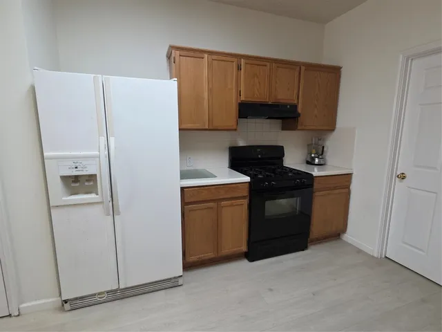 a kitchen with a refrigerator sink and cabinets