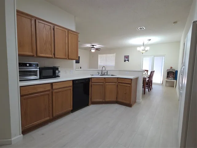 a kitchen with a sink cabinets and wooden floor