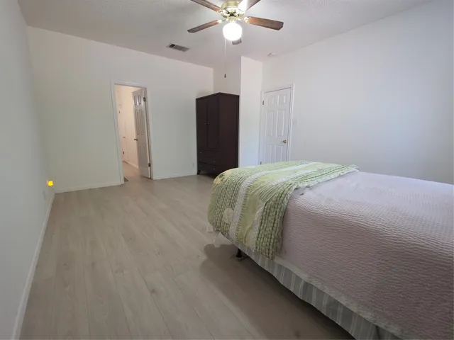 a bedroom with a bed and a ceiling fan