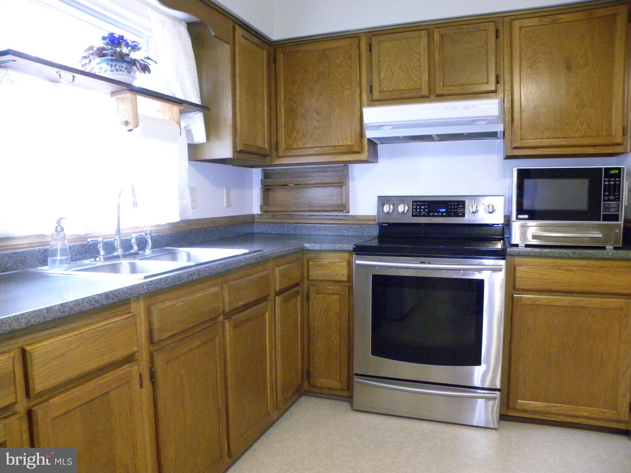 7415 Bull Run Road Manassas, VA 20111 - Photo 20 of 30 a kitchen with stainless steel appliances granite countertop a stove and a microwave