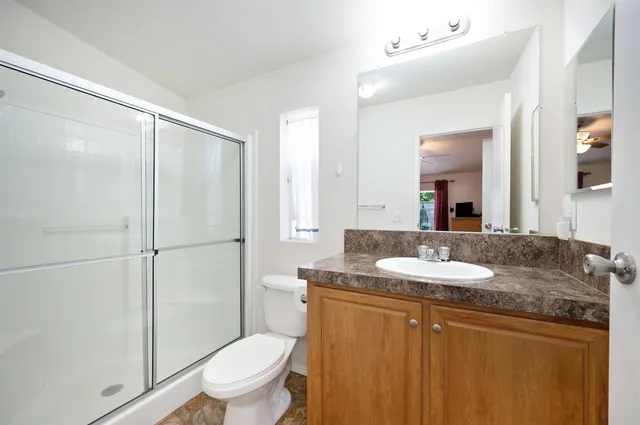a bathroom with a granite countertop sink toilet and shower