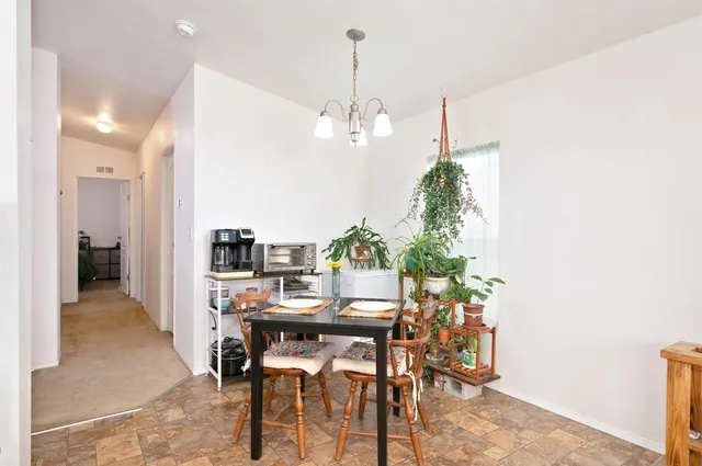 a view of a dining room with furniture and a chandelier