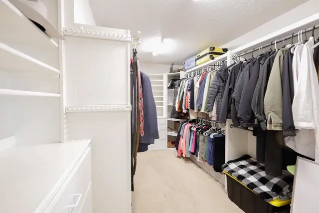 a view of walk in closet with clothes and shoes