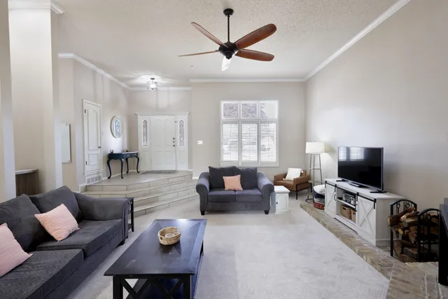 a living room with furniture a flat screen tv and a window