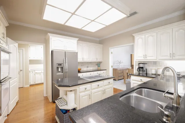 a kitchen with stainless steel appliances granite countertop a sink refrigerator and cabinets