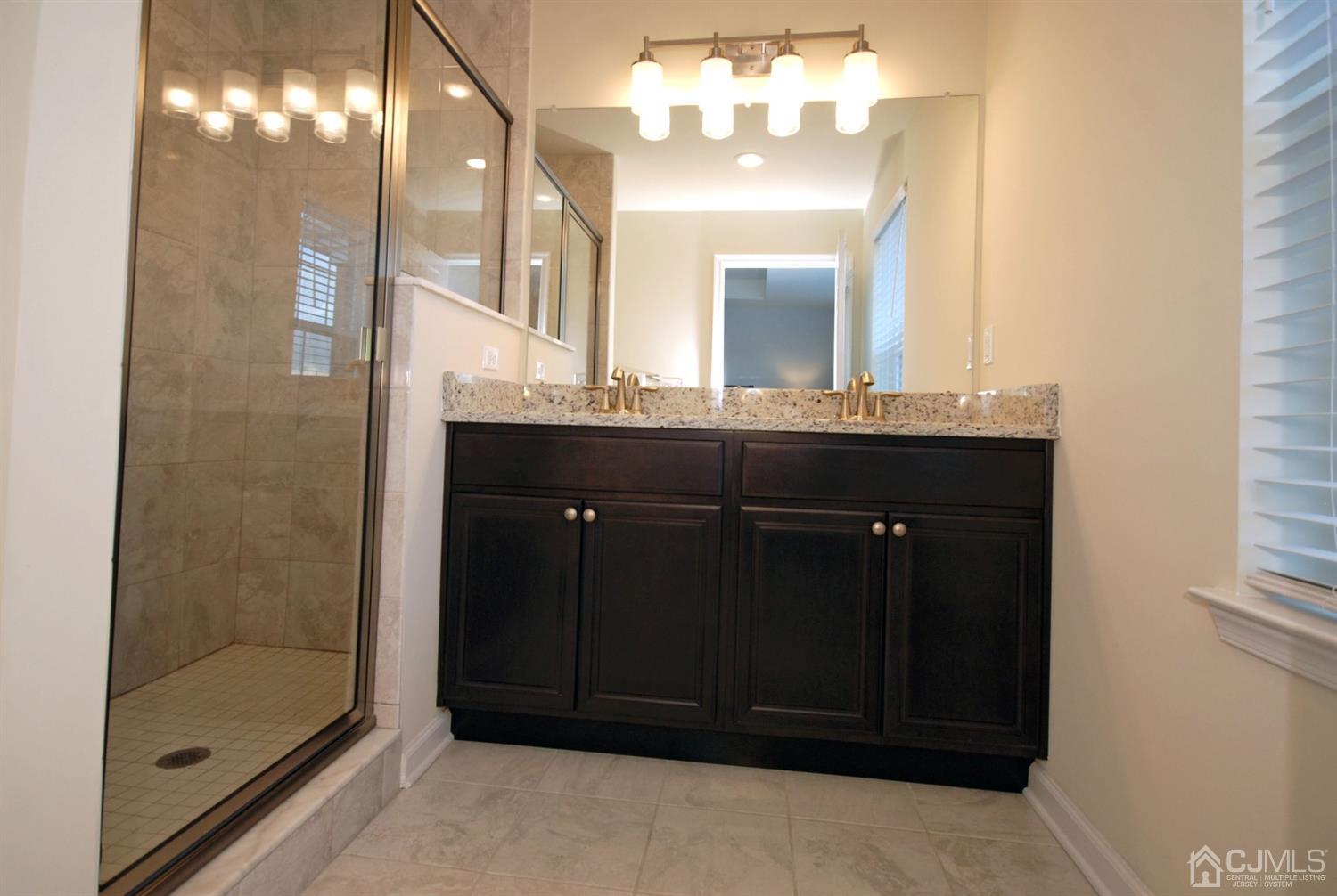 9 Flagger Lane Hamilton, NJ 08619 - Photo 16 of 24 a bathroom with a double vanity sink and a mirror
