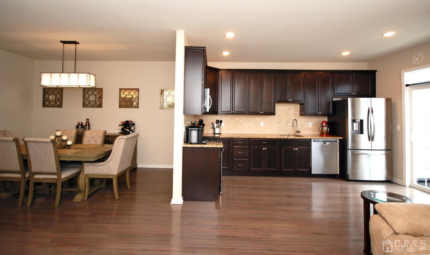 9 Flagger Lane Hamilton, NJ 08619 - Photo 6 of 24 a kitchen with stainless steel appliances a refrigerator a stove a sink a dining table and chairs