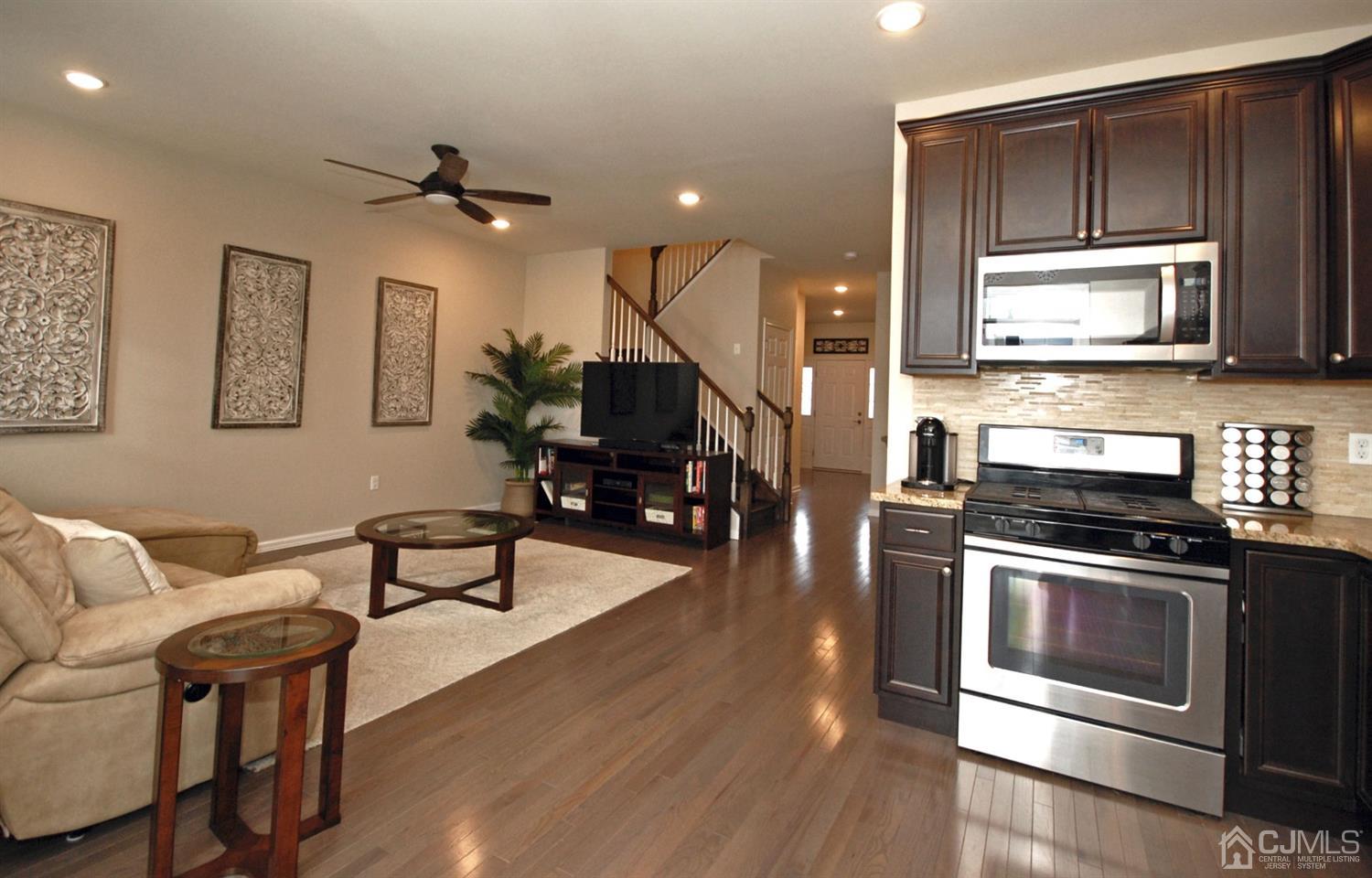 9 Flagger Lane Hamilton, NJ 08619 - Photo 9 of 24 a kitchen with stainless steel appliances kitchen island granite countertop a stove a sink dishwasher and a microwave with wooden floor