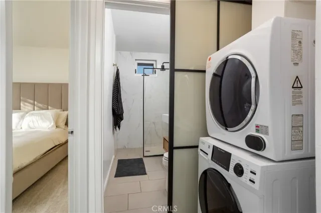 a utility room with dryer washer and a view of living room