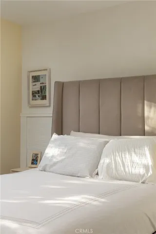 a bedroom with a bed and a painting on the wall