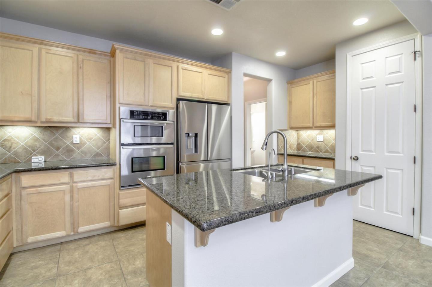 5306 Fioli Loop San Ramon, CA 94582 - Photo 4 of 14 a kitchen with stainless steel appliances granite countertop a sink a stove and a refrigerator