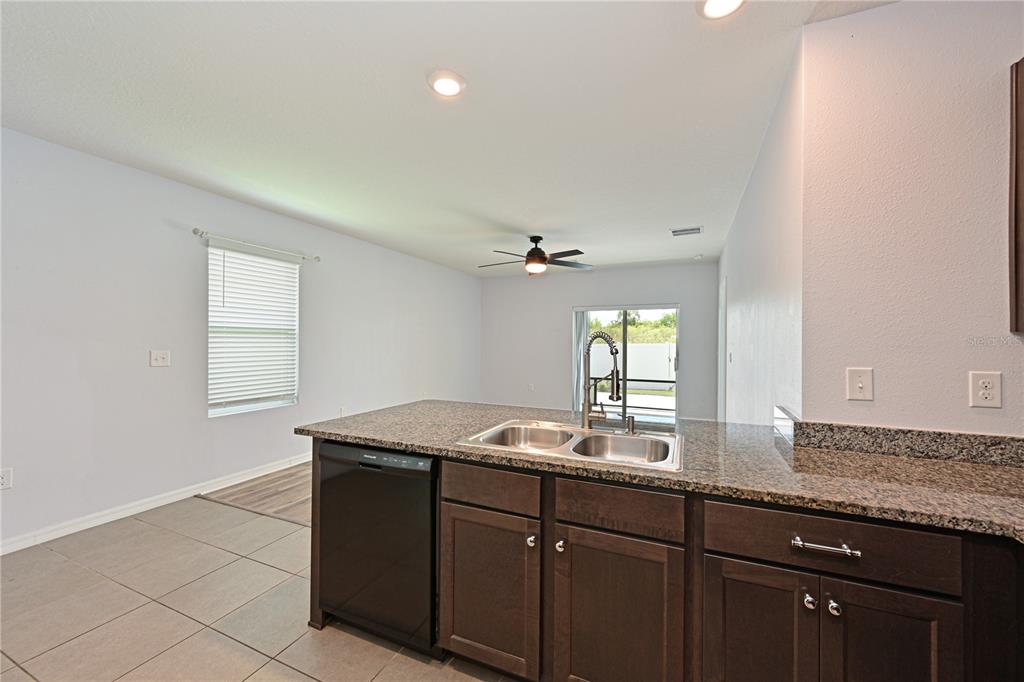 4919 Wedgeleaf Way Palmetto, FL 34221 - Photo 23 of 35 a kitchen with granite countertop a sink and a window