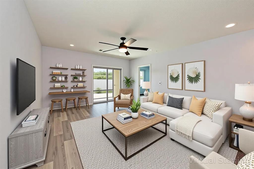4919 Wedgeleaf Way Palmetto, FL 34221 - Photo 3 of 35 a living room with furniture a flat screen tv and a large window