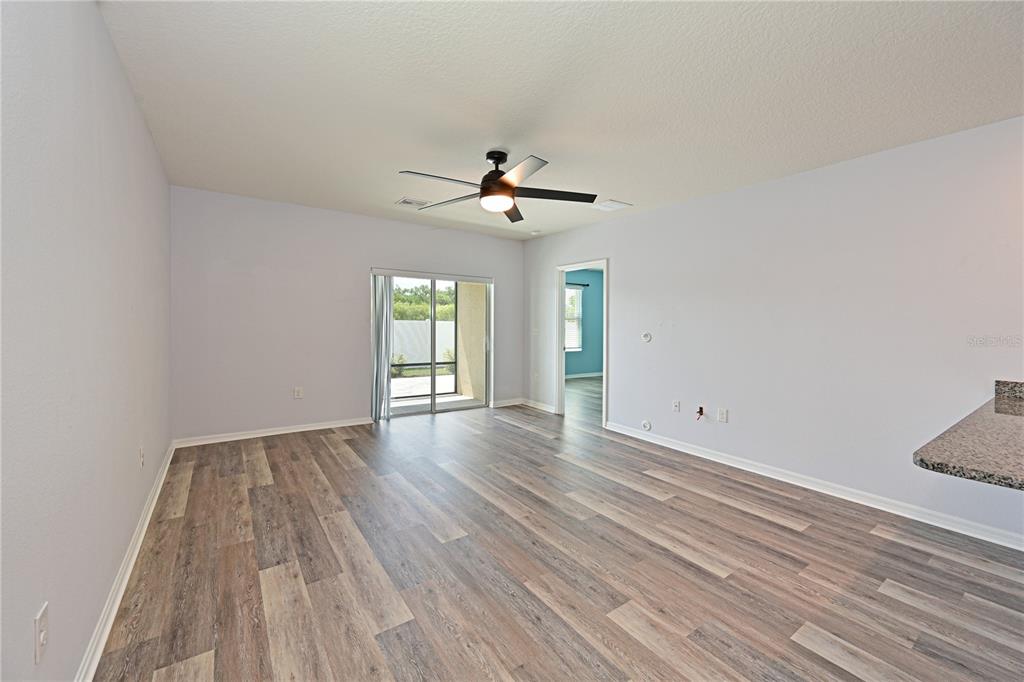 4919 Wedgeleaf Way Palmetto, FL 34221 - Photo 4 of 35 wooden floor in an empty room with a window