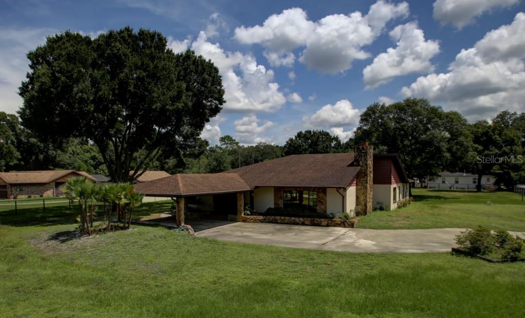 a view of a house with backyard and sitting area