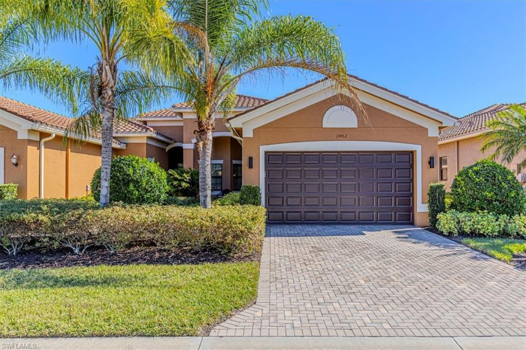 View of front of property featuring stucco siding, decorative driveway, a tile roof, and a garage