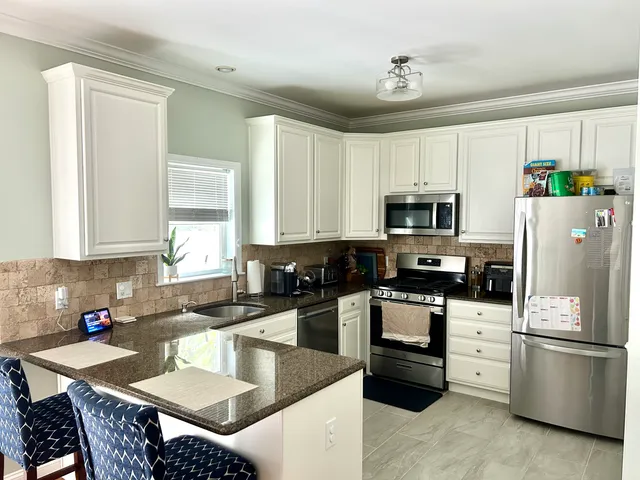 a kitchen with stainless steel appliances granite countertop a refrigerator stove microwave and sink