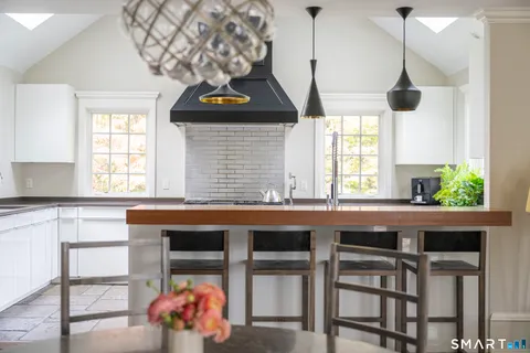 a kitchen with a sink a window and chairs