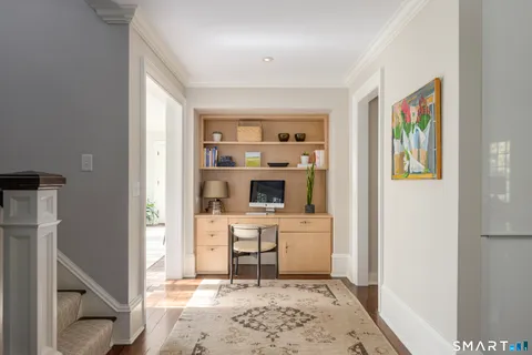 a living room with stainless steel appliances kitchen island granite countertop a refrigerator and a sink