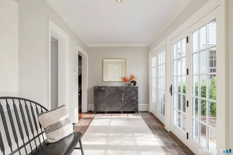 a view of a hallway with wooden floor and windows