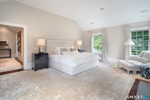 a bedroom with a bed and a large window