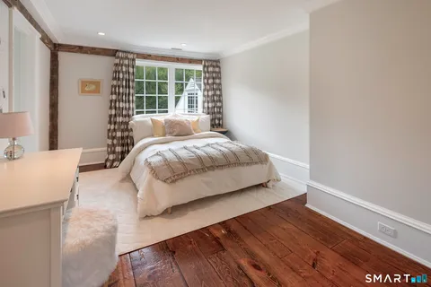 a bedroom with a bed and a large window