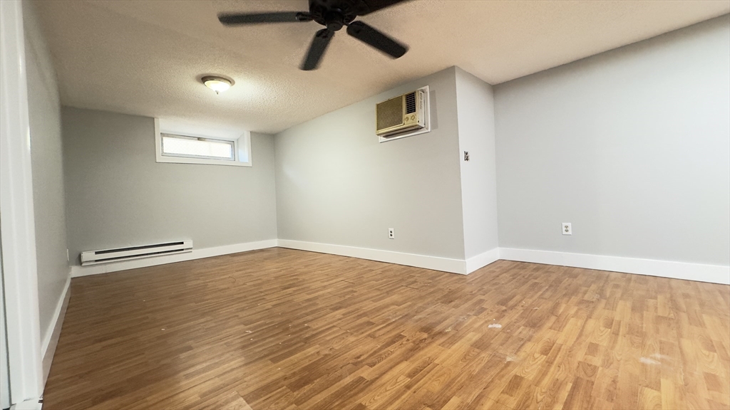 150 Pleasant Street, Unit 1 Lowell, MA 01852 - Photo 11 of 19 a view of an empty room with wooden floor