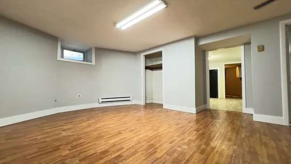 a view of an empty room with wooden floor