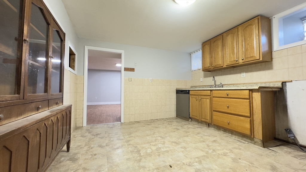 150 Pleasant Street, Unit 1 Lowell, MA 01852 - Photo 13 of 19 a view of a kitchen with cabinets and wooden floor