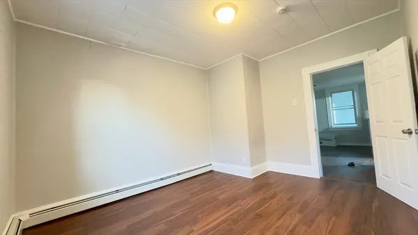 an empty room with wooden floor and closet