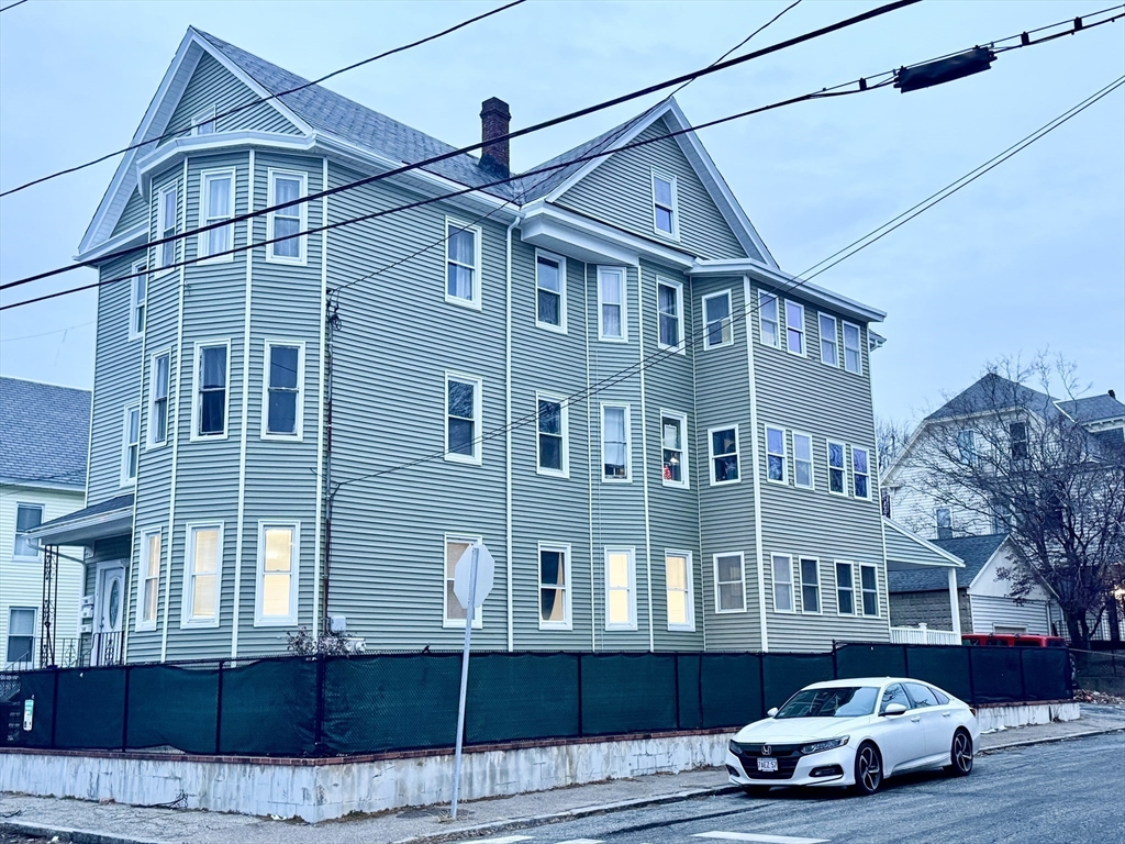 150 Pleasant Street, Unit 1 Lowell, MA 01852 - Photo 2 of 19 a car parked in front of a white building