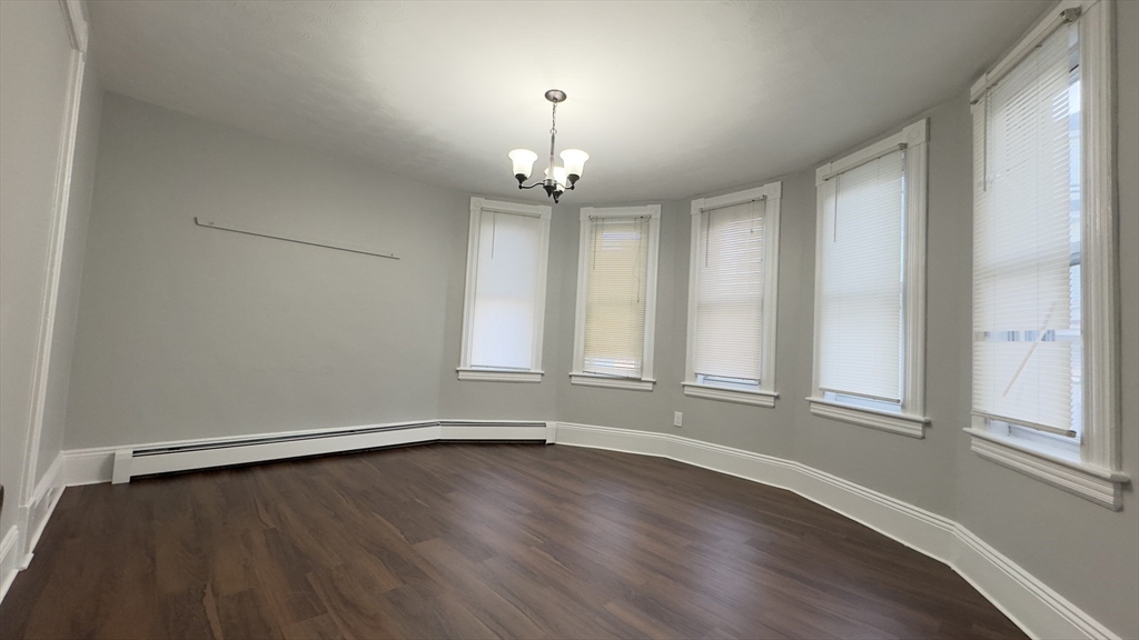 150 Pleasant Street, Unit 1 Lowell, MA 01852 - Photo 3 of 19 wooden floor in an empty room with a window