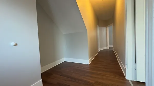 a view of a hallway with wooden floor