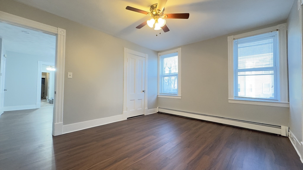 150 Pleasant Street, Unit 1 Lowell, MA 01852 - Photo 6 of 19 wooden floor in an empty room with a window