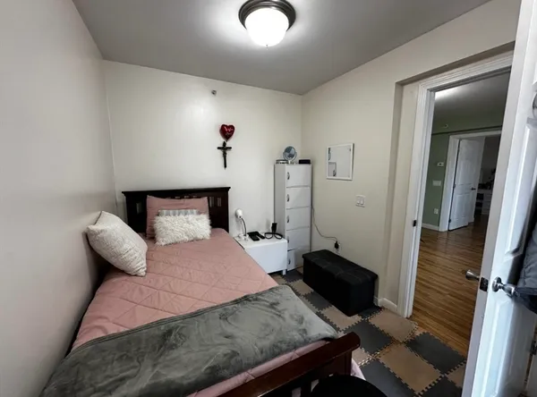a bedroom with a bed and wooden floor