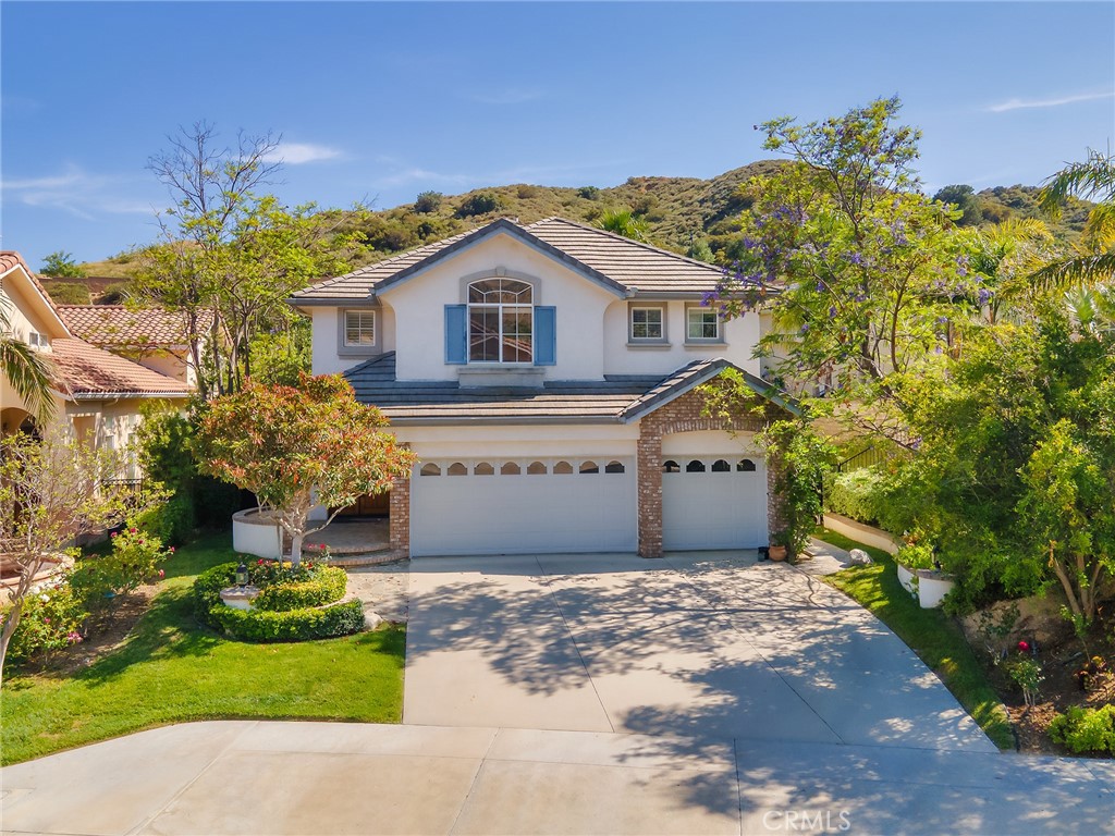 20316 Wynfreed Lane Porter Ranch, CA 91326 - Photo 42 of 51 a front view of a house with a garden