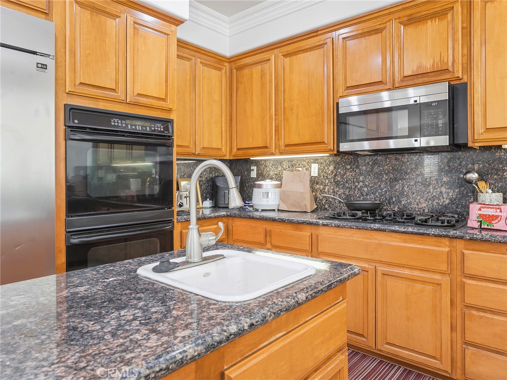 20316 Wynfreed Lane Porter Ranch, CA 91326 - Photo 8 of 51 a kitchen with granite countertop a sink a stove and cabinets
