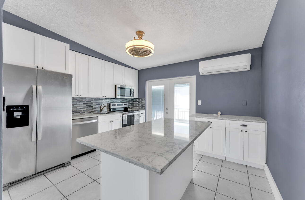 67 Coral Drive, Unit 1 Key Largo, FL 33037 - Photo 16 of 23 a kitchen with stainless steel appliances granite countertop a sink and a refrigerator