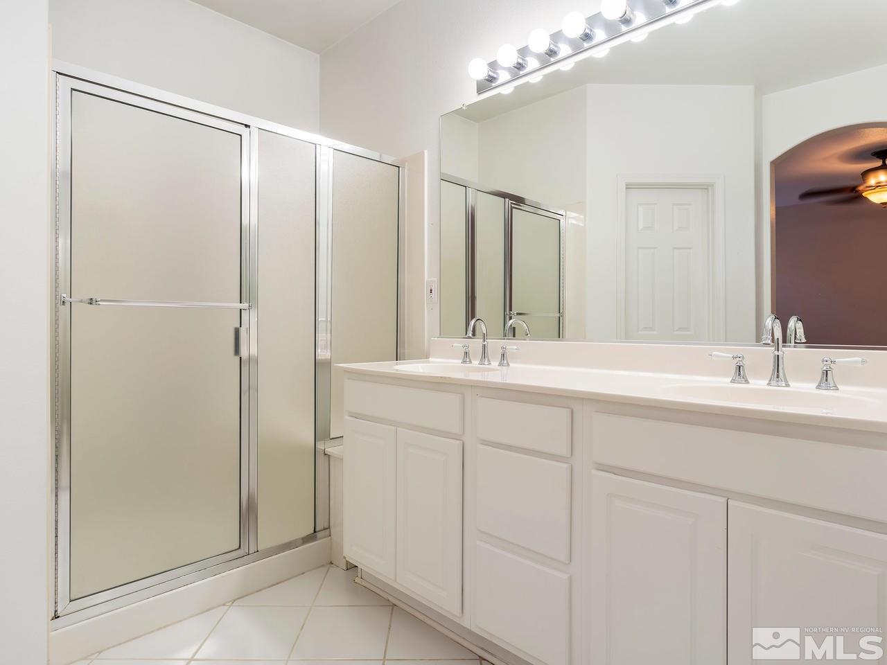 10402 Gold Trail Drive Reno, NV 89521 - Photo 11 of 16 a bathroom with a double vanity sink and mirror