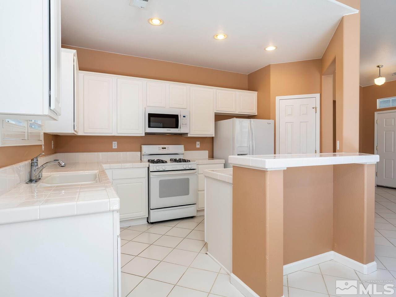 10402 Gold Trail Drive Reno, NV 89521 - Photo 7 of 16 a kitchen with a sink a stove and refrigerator