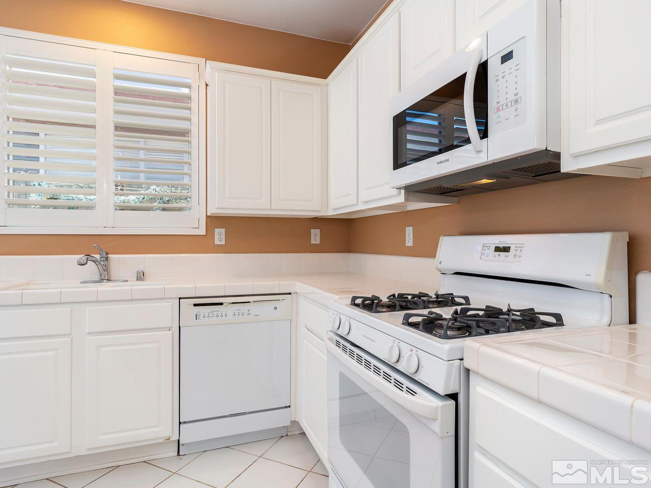 10402 Gold Trail Drive Reno, NV 89521 - Photo 8 of 16 a kitchen with white cabinets and appliances