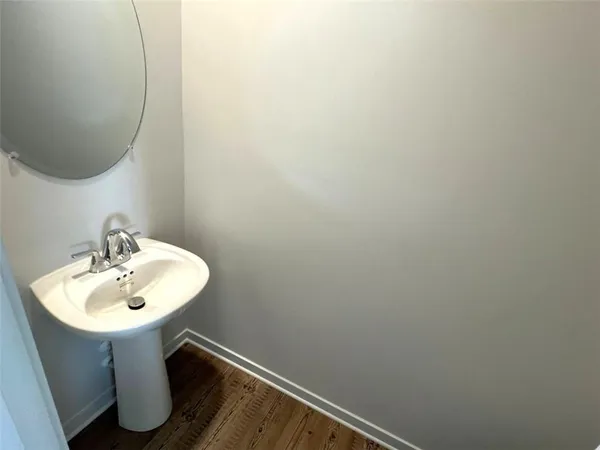 a view of a small space with wooden floor and fan