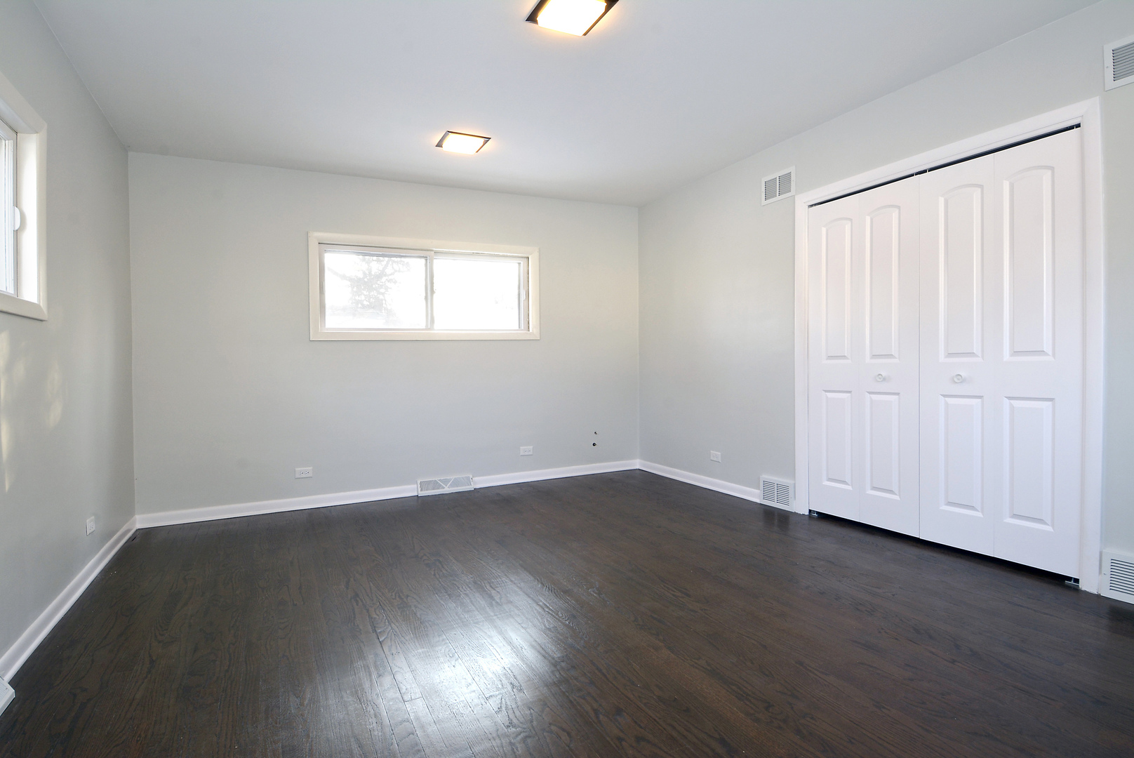 1322 West Central Road Mount Prospect, IL 60056 - Photo 12 of 28 an empty room with wooden floor and windows