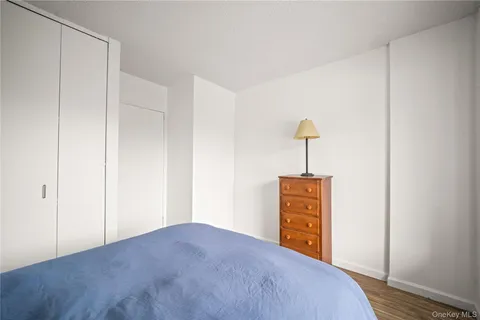 a bedroom with a bed and a wooden floor