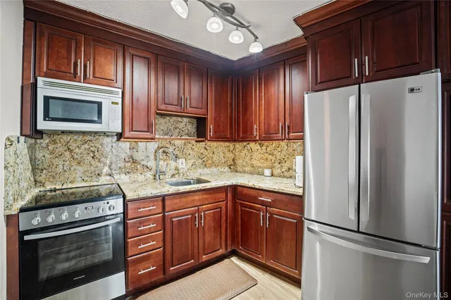 a kitchen with granite countertop stainless steel appliances and wooden cabinets