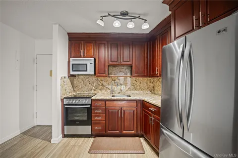 a kitchen with stainless steel appliances granite countertop a refrigerator and a stove