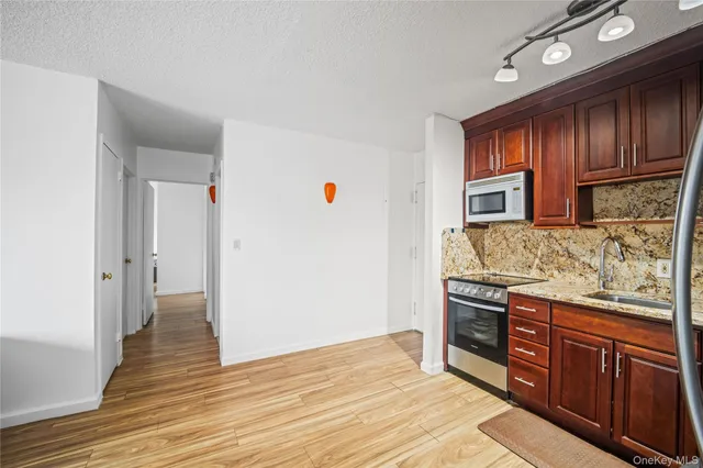 a kitchen with stainless steel appliances granite countertop a stove and a wooden cabinets