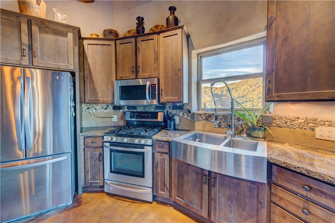 17445 South La Cienega Ranch Road Yucca, AZ 86438 - Photo 13 of 52 a kitchen with stainless steel appliances granite countertop a refrigerator a stove and a sink with wooden floors