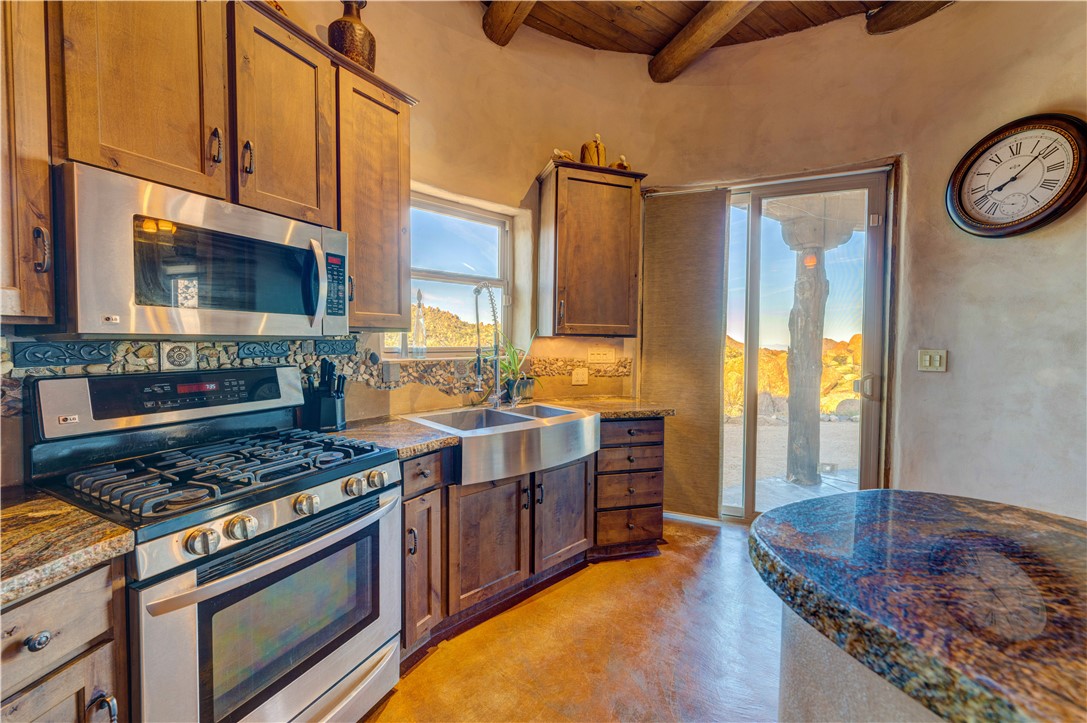 17445 South La Cienega Ranch Road Yucca, AZ 86438 - Photo 14 of 52 a kitchen with stainless steel appliances granite countertop a stove and a sink